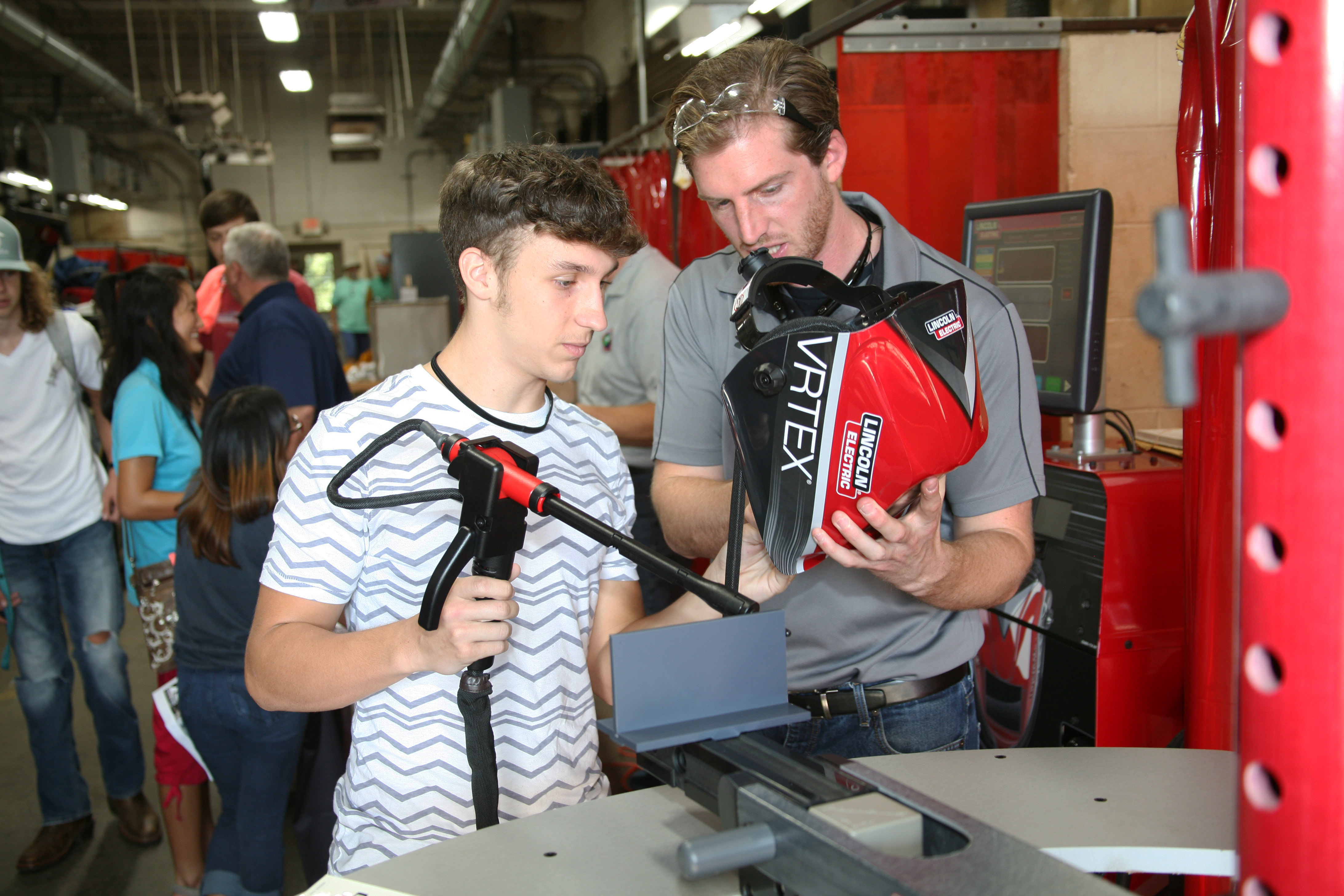 Curt Metz (right) of Lincoln Electric, goes over the welding simulator with Kaleb Brondaway (left) of Rome High School.