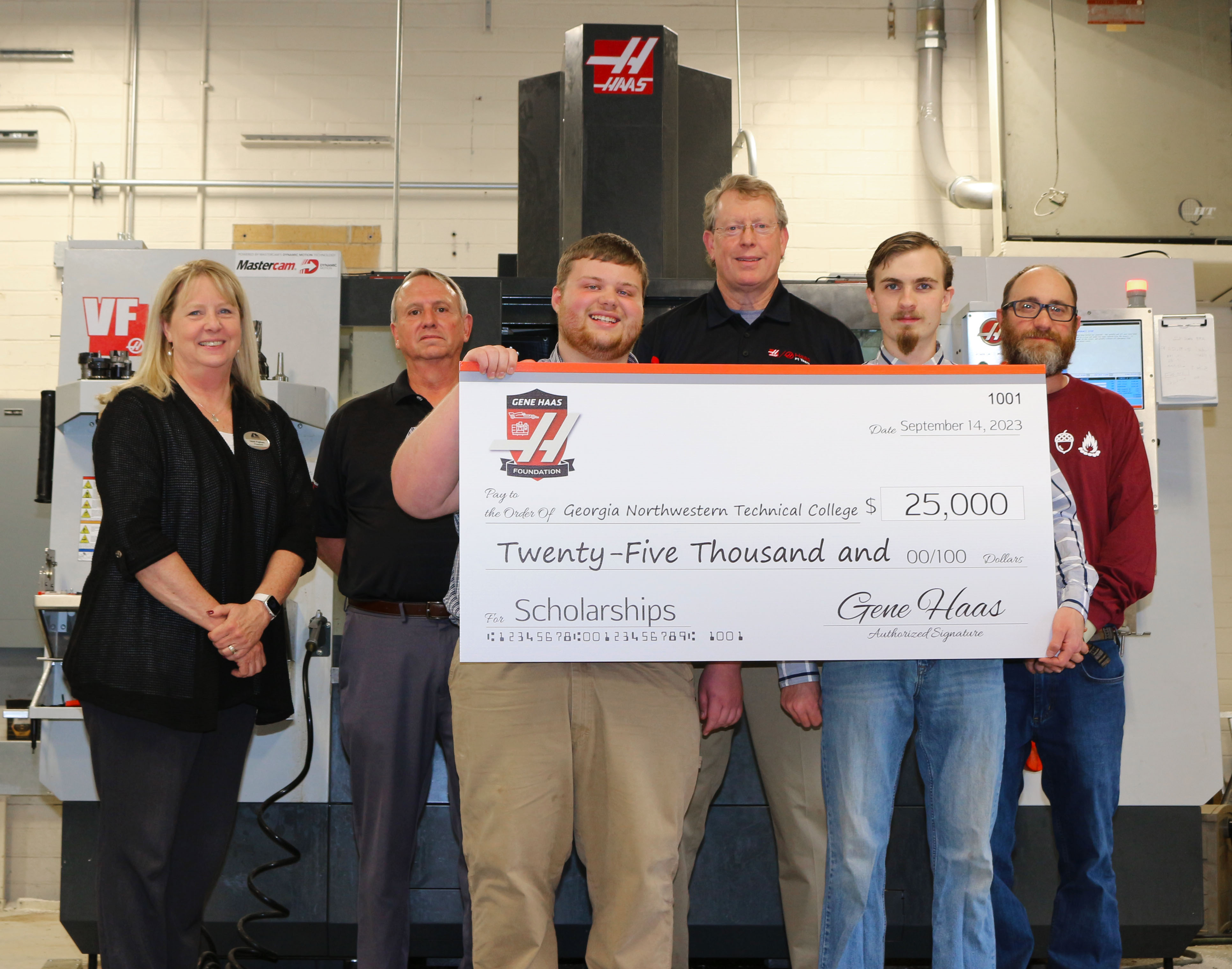 The Gene Haas Foundation presents a grant of $25,000 to GNTC on Thursday, Oct. 19. (From left) Dr. Heidi Popham, president of GNTC; David Aycock, sales engineer for Phillips Corporation/Haas Factory Outlet; GNTC student Jason Ward; Philip Shirley, Precision Machining and Manufacturing instructor; GNTC student Jeshua Freeman; and Bart Jenkins, director of Precision Machining and Manufacturing at GNTC, stand in front of a Haas VF2 Computer Numerical Control milling machine at the Floyd County Campus in Rome. Freeman and Ward received scholarships this semester that are funded through the Gene Haas Foundation grant.