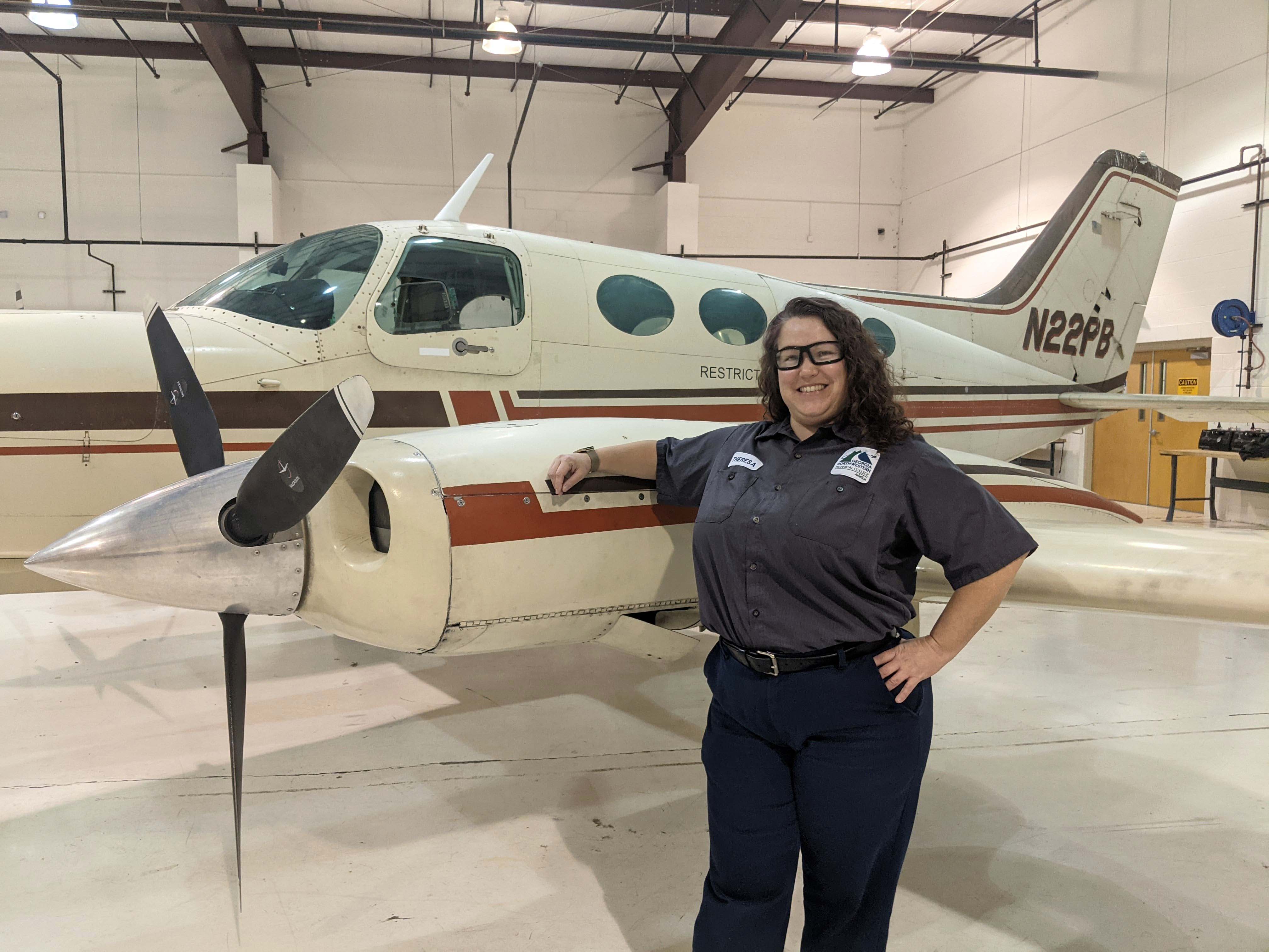 GNTC student Theresa Harper stands next to a plane in the GNTC Aviation Training Center hangar. Harper is the recipient of the HAI/WAI Maintenance Technician Certificate Scholarship and will receive recognition at the 32nd Annual International Women in Aviation Conference in March. 