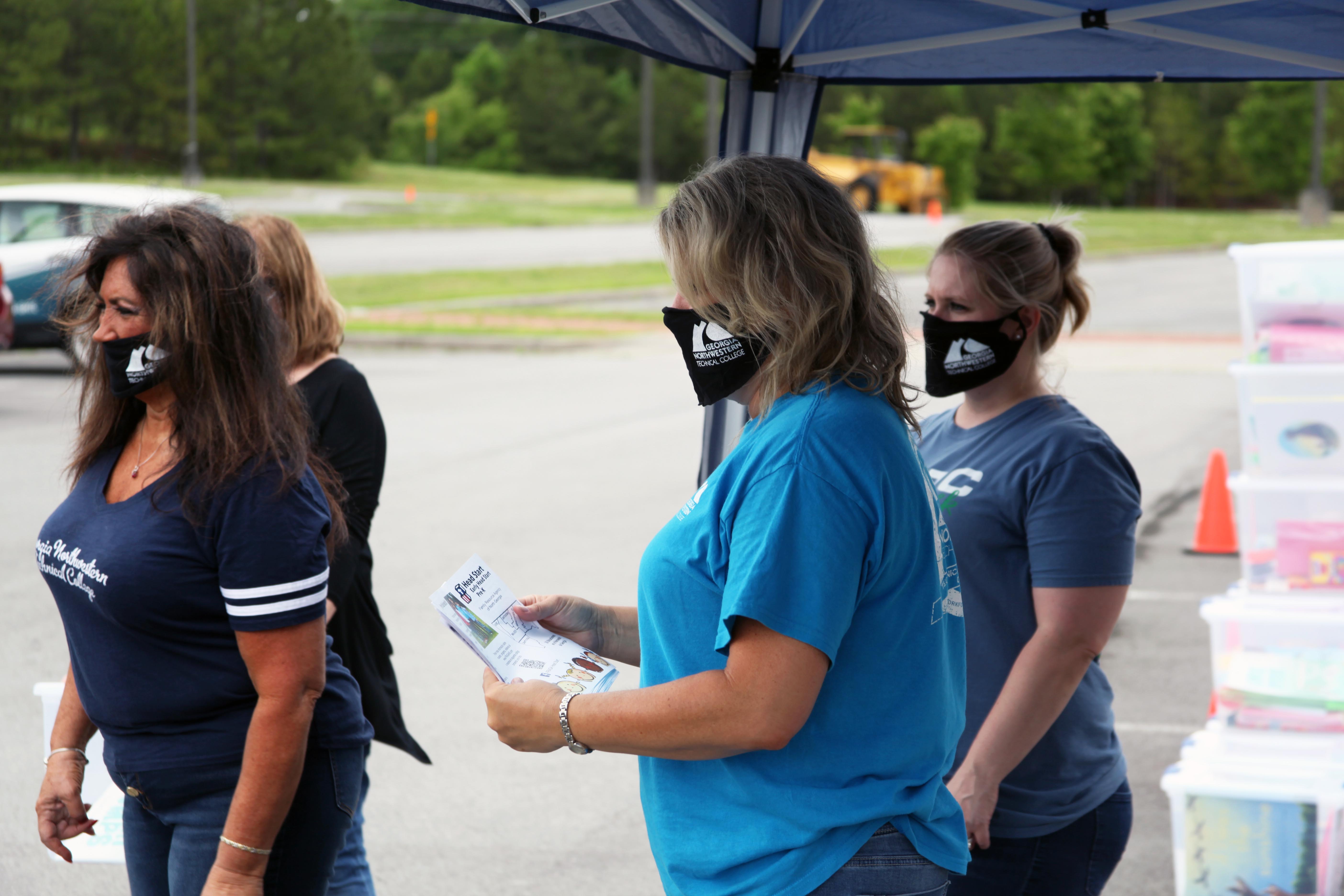 Marilyn Grandstaff (from left), GNTC Career Services coordinator; Tracy Gentry, GNTC student success coach; and Monica Swank, GNTC Administrative Services, stand ready for the next wave of cars to arrive during the mobile food pantry on Wednesday, May 27.