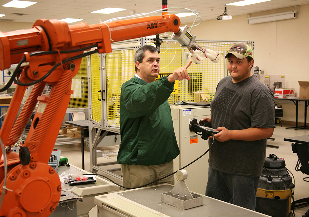 Greg Smith (left), instructor of Robotics and Engineering at the Floyd County Schools College and Career Academy (FCSCCA), teaches Camron Roubieu (right), of Coosa High School, how to operate an industry-grade robot. Robotics and Engineering is a Move On When Ready program between FCSCCA and Georgia Northwestern that gives students the opportunity to earn college credits while still in high school. Students may also use the credits earned towards an industry certificate or associate degree.
