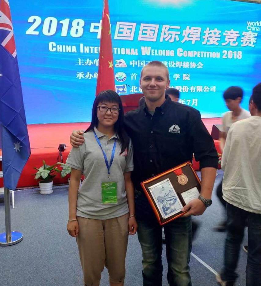 Ryan Fincher (right) of Cedartown poses for a picture with his interpreter after winning the bronze medal in in the China International Welding Competition 2018 in Beijing.
