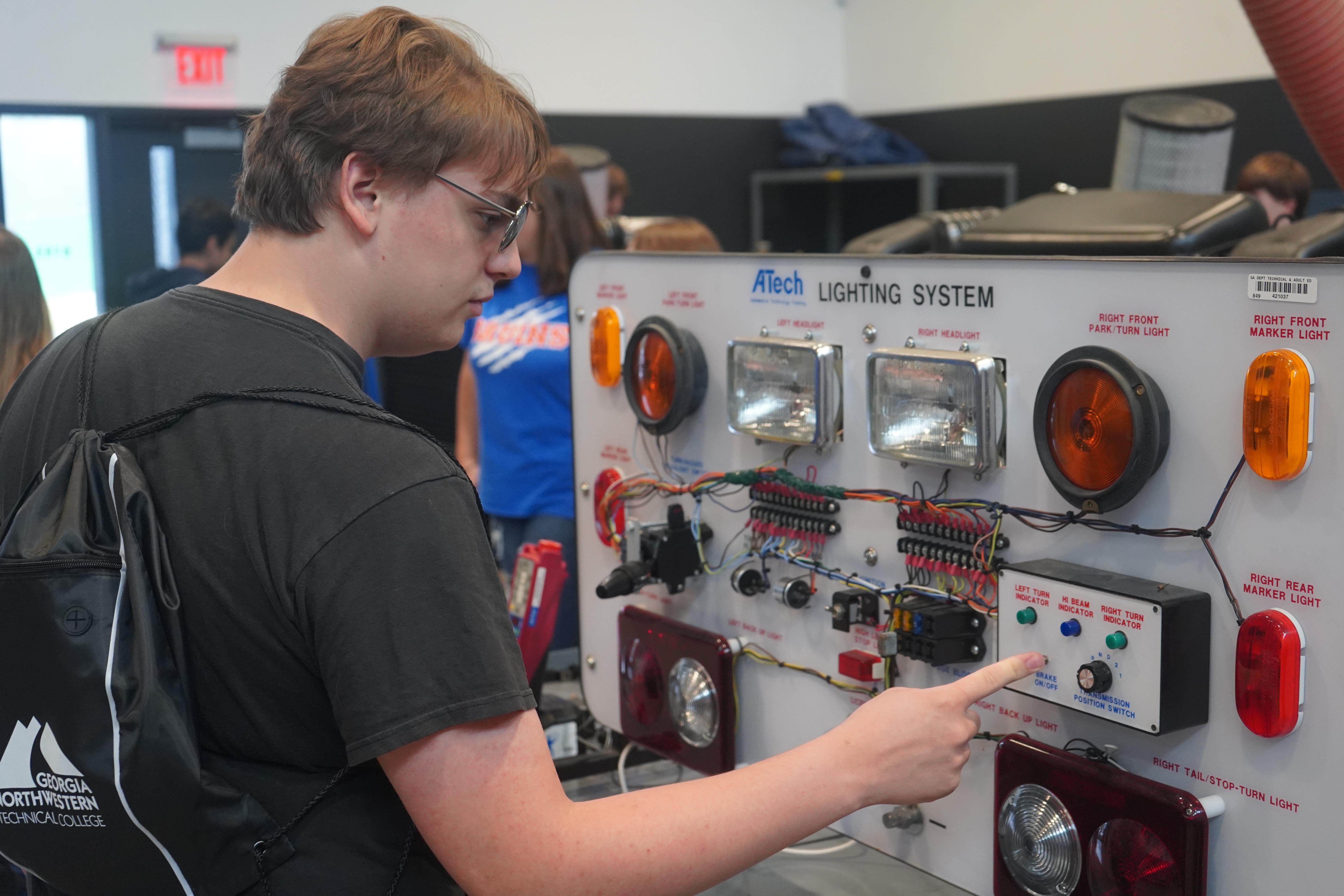 Turner Jenkins of Northwest Whitfield High School examines the lighting system in the Diesel Equipment Technology lab during Industrial Career Day at GNTC.
