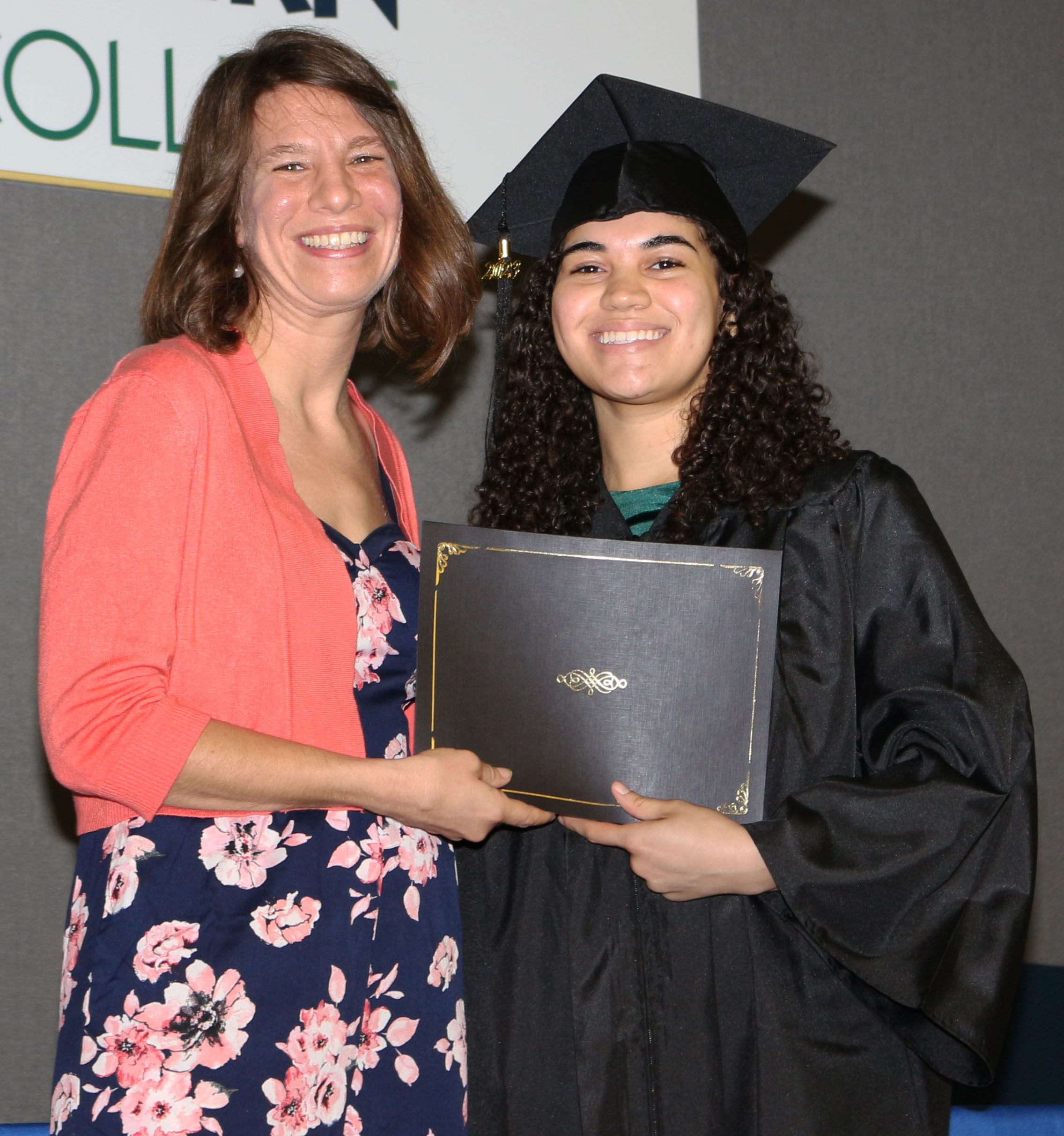 GNTC Youth Services Instructor Kristen Sheeley (left) presents Audrey Maxwell with her GED® diploma